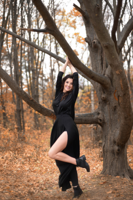 Девушка в чёрном длинном платье в осеннем лесу
