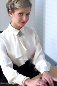 Белобрысая секретарша в белой рубашке позирует в офисе