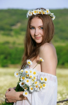 Красивая девушка в поле с ромашками